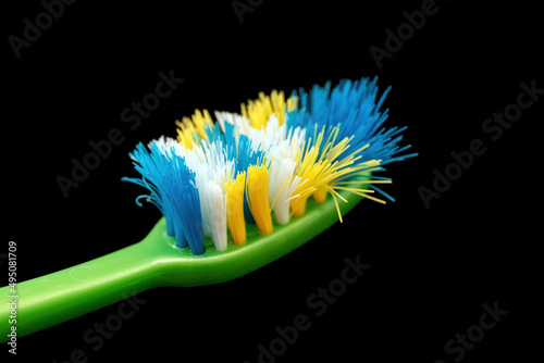 Isolated used toothbrush head against a black background