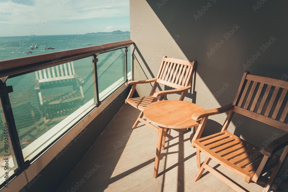 Fototapeta premium Wooden chairs with beautiful sea view sunny day background in terrace room hotel. Travel summer beach holiday and hotel business concept.