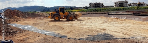 earthworks at a construction site, backfilling with inert material, replacement of clay soil, laying of insulating film on treated clay soil  photo