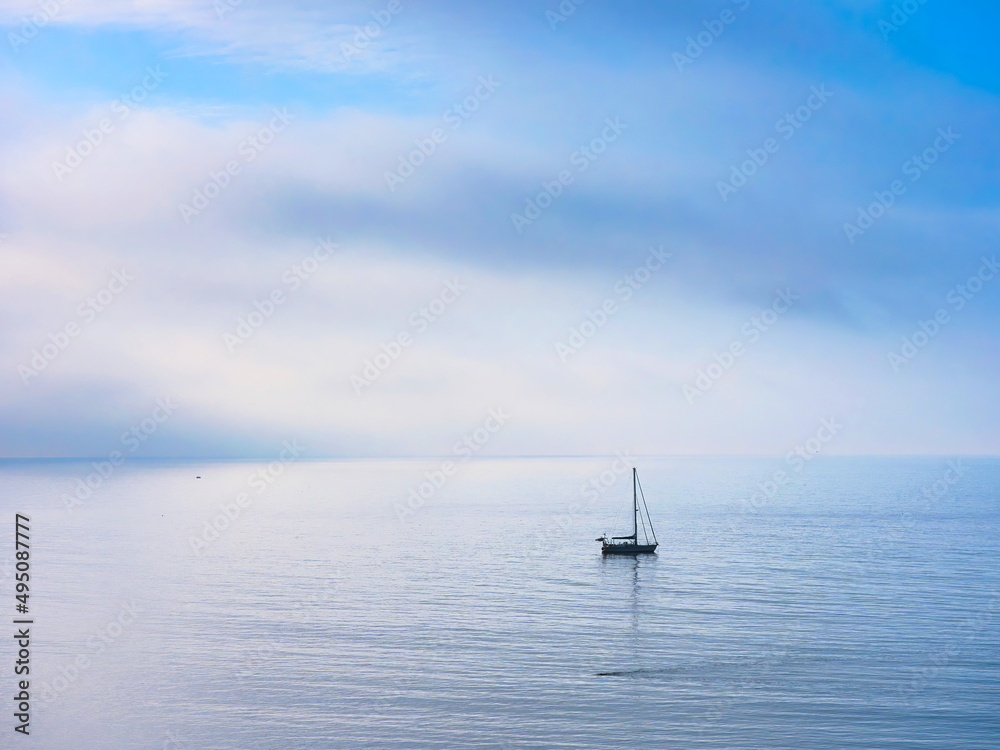 Lone Sailboat on a Misty Morning