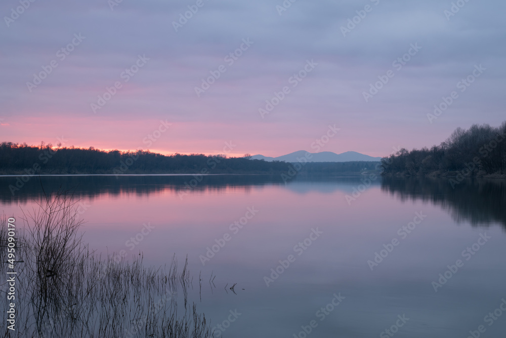 Calm dusk over Sava river with fading light with mountain in haze - beautiful natural landscape