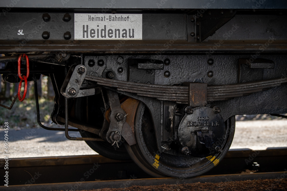 close-up shot of a railway bogie of a narrow gauge railroad waggon. Text on white reads 