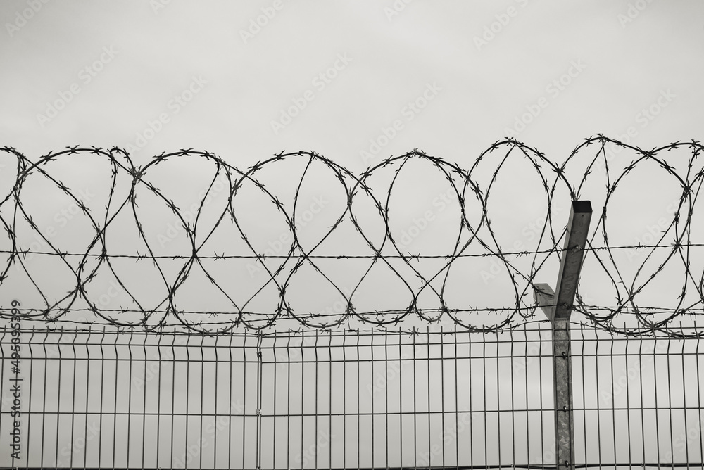 fence with barbed wire on cloudy sky fence with barbed wire on cloudy sky