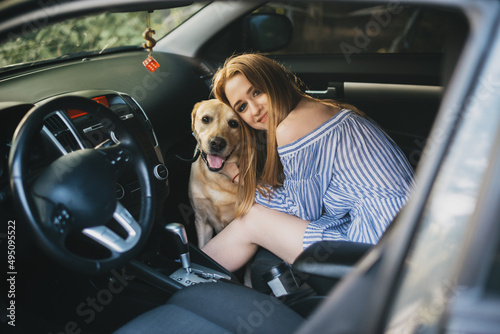 Woman with labrador retriever dog in car