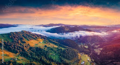 Majestic sunrise in Carpathian mountains. Fog spreads on the valley of Snidavka village  Ukraine  Europe. Picturesque summer landscape of mountain hills glowing by first sunlight.