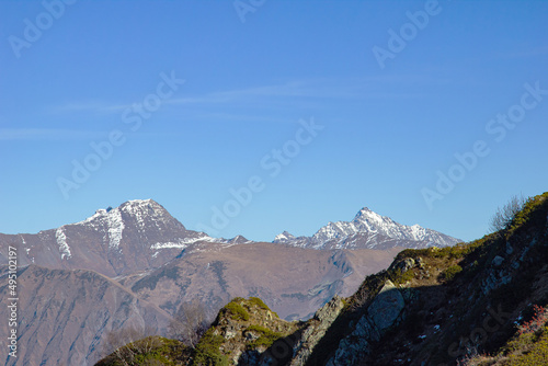 Beautiful landscape in the mountains with peaks against the blue sky and valleys covered with grass