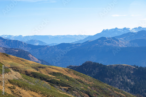 Beautiful landscape in the mountains with peaks against the blue sky and valleys covered with grass