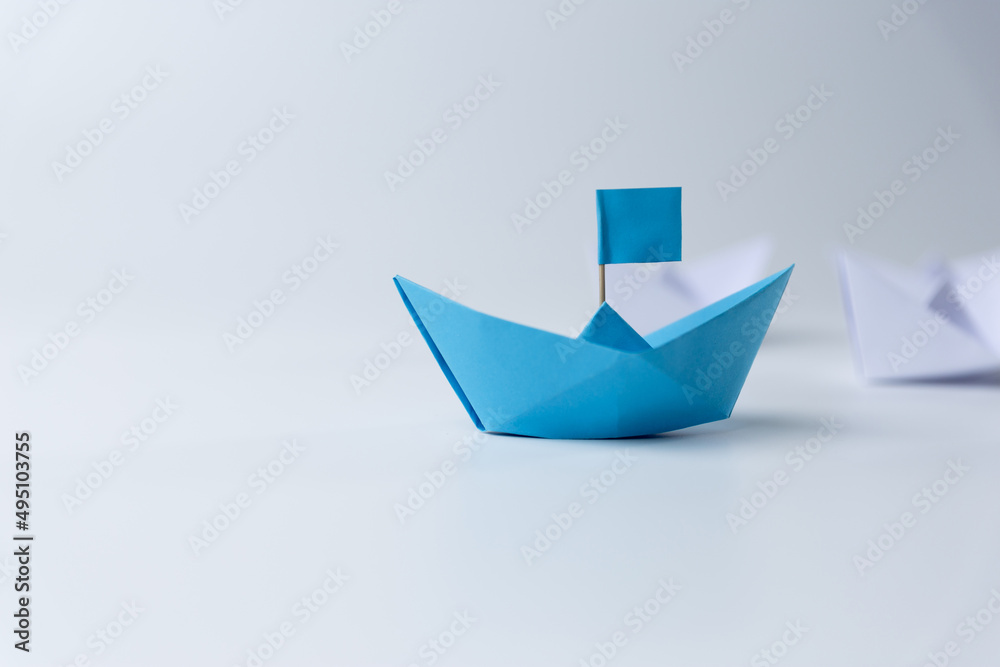 Leadership and teamwork, Blue leader paper ship leading hind white on white background. Leadership and teamwork, Blue leader paper ship leading hind white on white background.