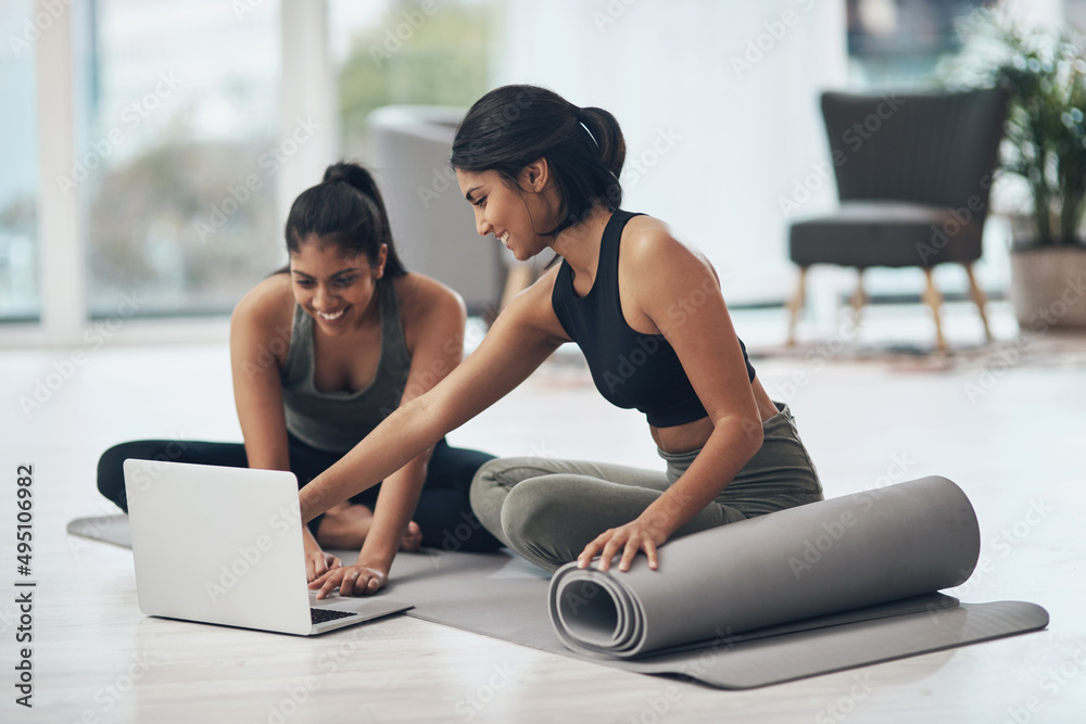 Lets start our virtual session. Shot of two young women using a laptop while working out at home. Lets start our virtual session. Shot of two young women using a laptop while working out at home.