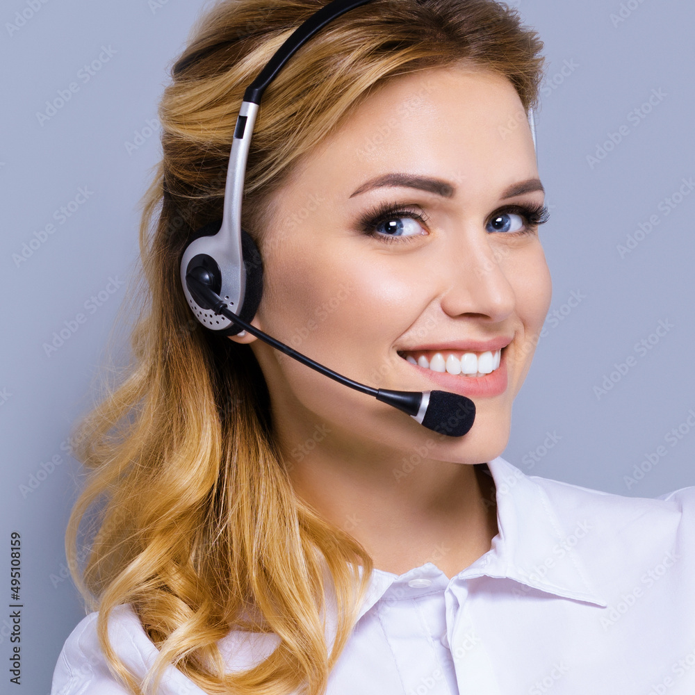 Face portrait of support phone operator in headset, against grey color background. Consulting and assistance service call center. Answering. Square composition picture. Face portrait of support phone operator in headset, against grey color background. Consulting and assistance service call center. Answering. Square composition picture.
