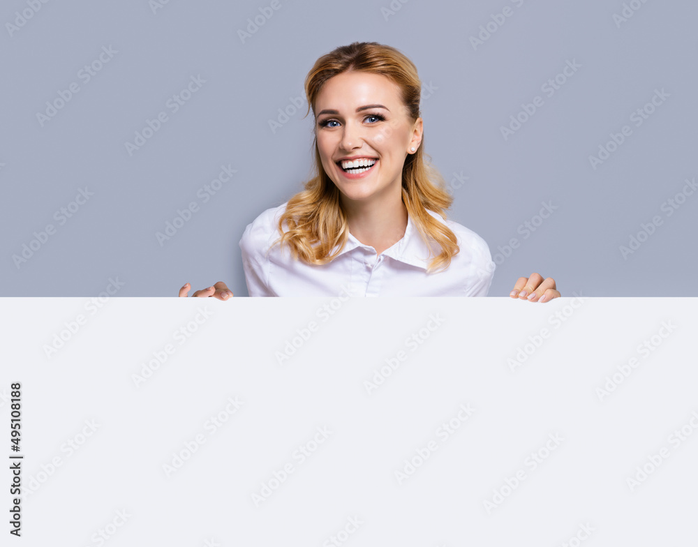 Very happy excited, laughing business woman in white confident clothing showing mockup banner signboard. Success and advertising concept. Copy space empty place for text or imaginary. Blond girl. Very happy excited, laughing business woman in white confident clothing showing mockup banner signboard. Success and advertising concept. Copy space empty place for text or imaginary. Blond girl.