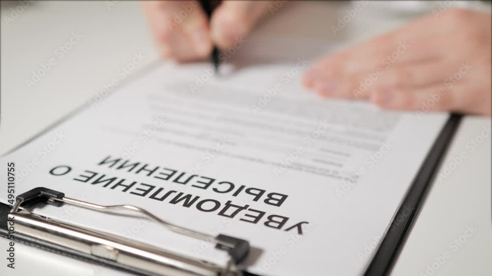 eviction notice in Russian-speaking countries. A person's hand signs a document. A warning. He is deprived of property, a mortgage on a mortgage. Unemployment and crisis. eviction notice in Russian-speaking countries. A person's hand signs a document. A warning. He is deprived of property, a mortgage on a mortgage. Unemployment and crisis.