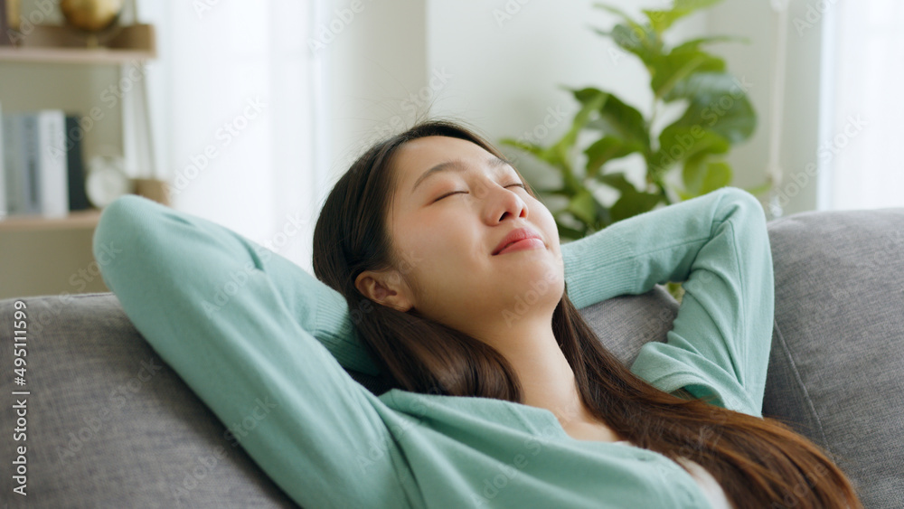 Young Asian woman feeling relax on sofa at home on weekend holiday. Young Asian woman feeling relax on sofa at home on weekend holiday.