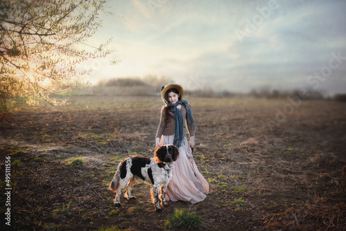 dziewczynka w starodawnym stroju z psem na spacerze