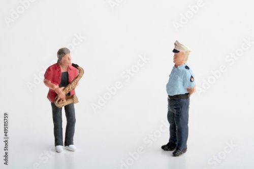 miniature figurine of a police officer taking a fine to street musician