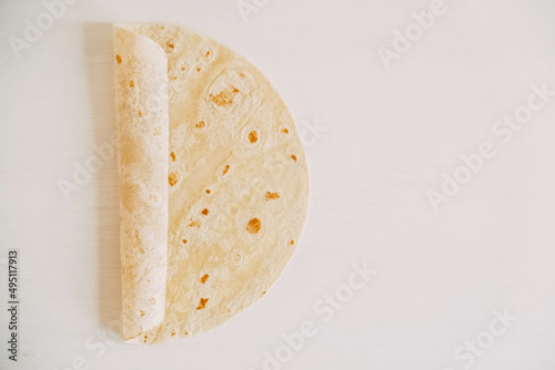Thin pita bread on a white wooden table background