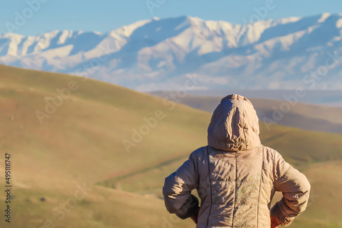 Traveler in the foothills against the backdrop of snow-capped mountains