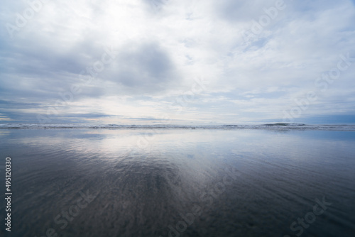 clouds reflected in water at beach
