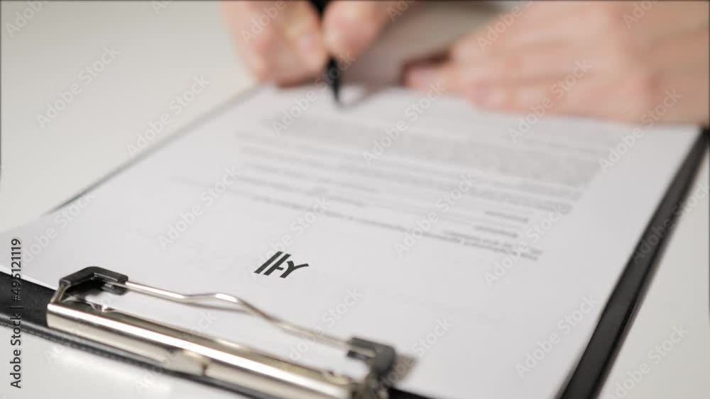 taxes in Korean-speaking. Man's hand signs a tax return. Tax individuals and legal entities. Budgeting. Accounting for expenses and income. taxes in Korean-speaking. Man's hand signs a tax return. Tax individuals and legal entities. Budgeting. Accounting for expenses and income.