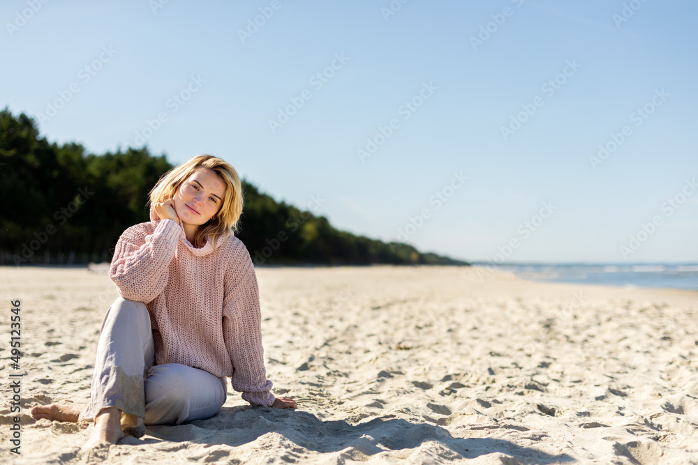 Happy woman on beach during cold spring weather