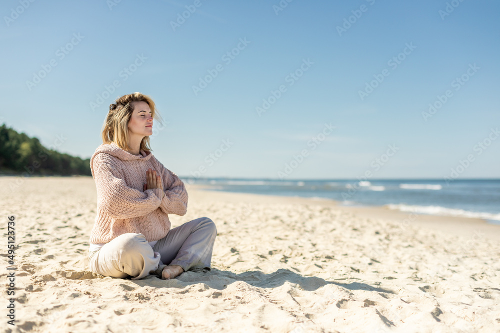 Practicing yoga and relaxing time on empty beach