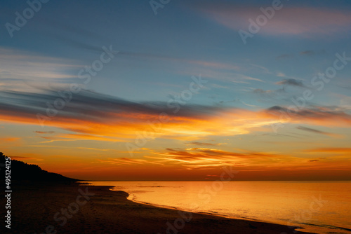 Stunning colorful sunset on the seashore with sandy beach