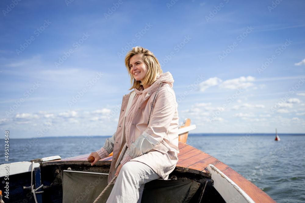 Young woman navigating sailboat sails on the lake