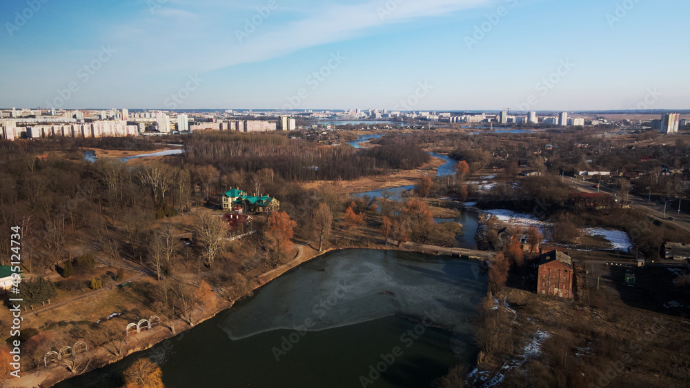 Spring city park. Park buildings. Pond with remnants of ice. Aerial photography.