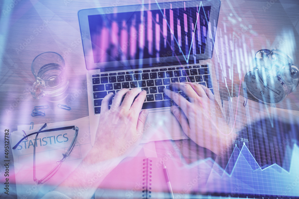 Double exposure of man's hands typing over laptop keyboard and forex chart hologram drawing. Top view. Financial markets concept. Double exposure of man's hands typing over laptop keyboard and forex chart hologram drawing. Top view. Financial markets concept.