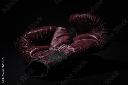 brązowe rękawice bokserskie po treningu na ciemnym tle