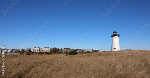 Edgartown lighthouse with a view of the city in the background and blue sky