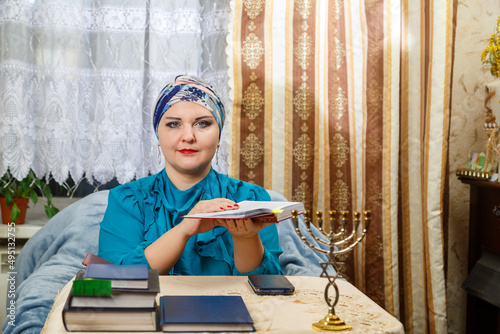 A female rabbi of the Reform Judaism community in Kisui Rosh at the table conducts a Torah lesson to parishioners. photo