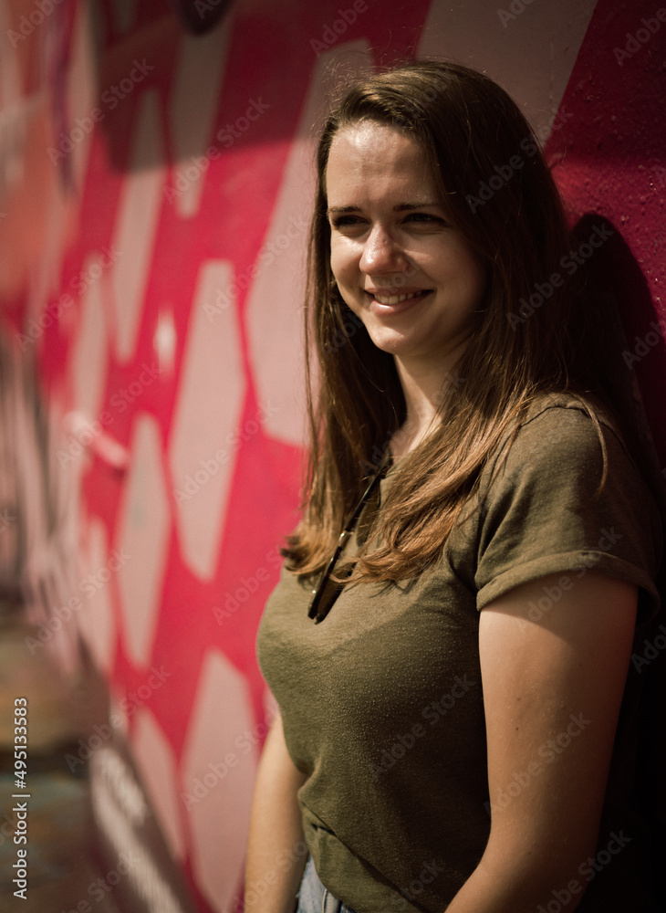 Young and beautiful woman leans against a colorful wall and poses for the camera - typical street style - travel photography Young and beautiful woman leans against a colorful wall and poses for the camera - typical street style - travel photography