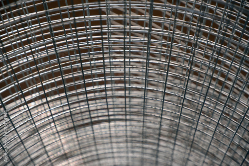 Construction grid with a square cell rolled into a roll. Close-up selective focus. A roll of mesh wire made of steel.