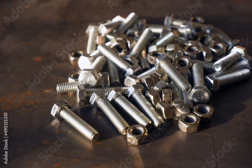 Shiny bolts and nuts on a steel table close-up. © Пётр Гребенев