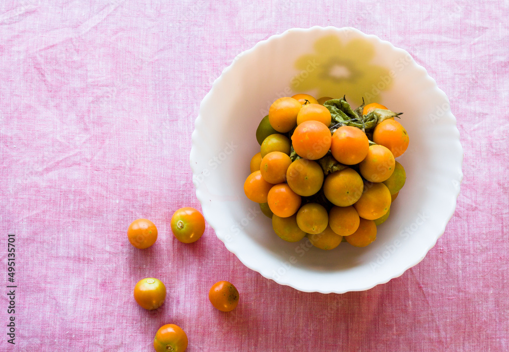 Bowl of healthy,fresh,juicy and sweet cape gooseberries,isolated on light background, Close up view of berries that are native to India and South America. Bowl of healthy,fresh,juicy and sweet cape gooseberries,isolated on light background, Close up view of berries that are native to India and South America.