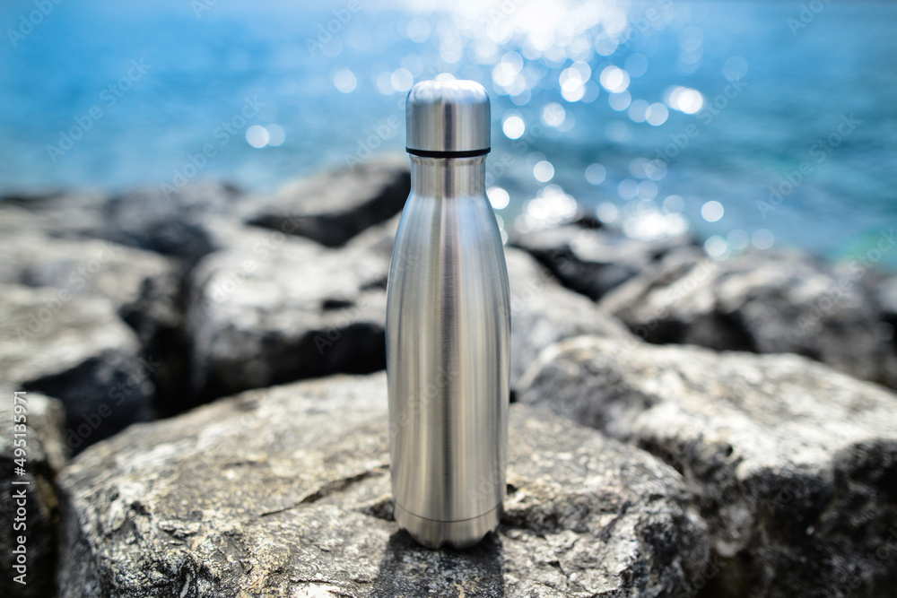 Steel eco thermo water bottle on the background of the lake. Be plastic free. Zero waste. Copy space. Zero waste, no plastic. Steel eco thermo water bottle on the background of the lake. Be plastic free. Zero waste. Copy space. Zero waste, no plastic.