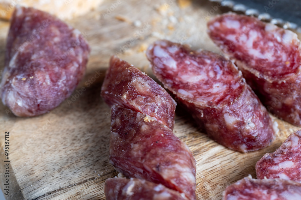 sliced pieces of sausage from meat are lying on a cutting board