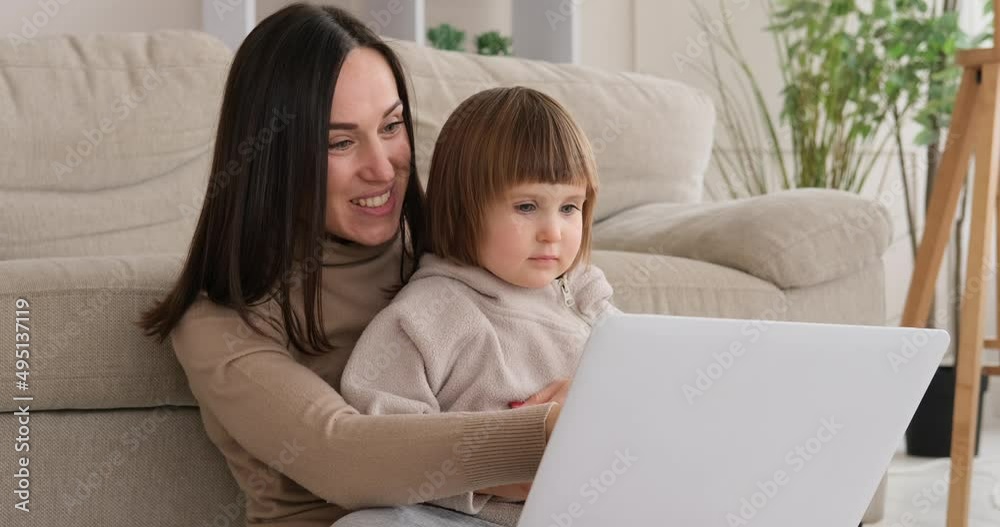 Playful mother and daughter watching movie on laptop at home Playful mother and daughter watching movie on laptop at home