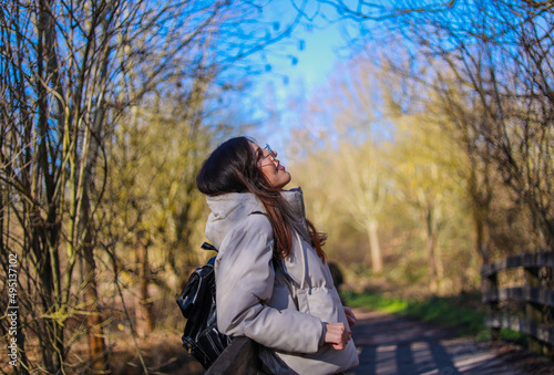 Attractive young woman smiling and taking a walk in the field with coat