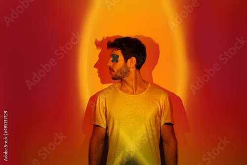 Young man in profile on background of red and orange lights