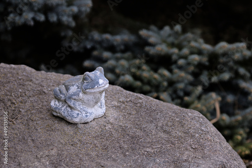 Ceramic garden decoration frog sitting on a rock