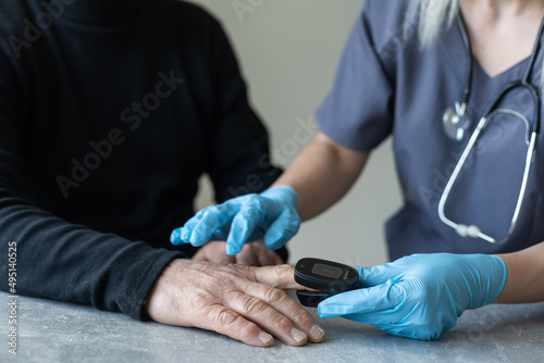 elderly man and nurse measuring pulse oximeter