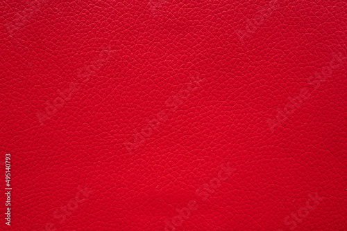 red faux leather background is used to wrap book covers or to repair everyday leather sofa seats and appliances. background and pattern on the red faux leather have space for text.