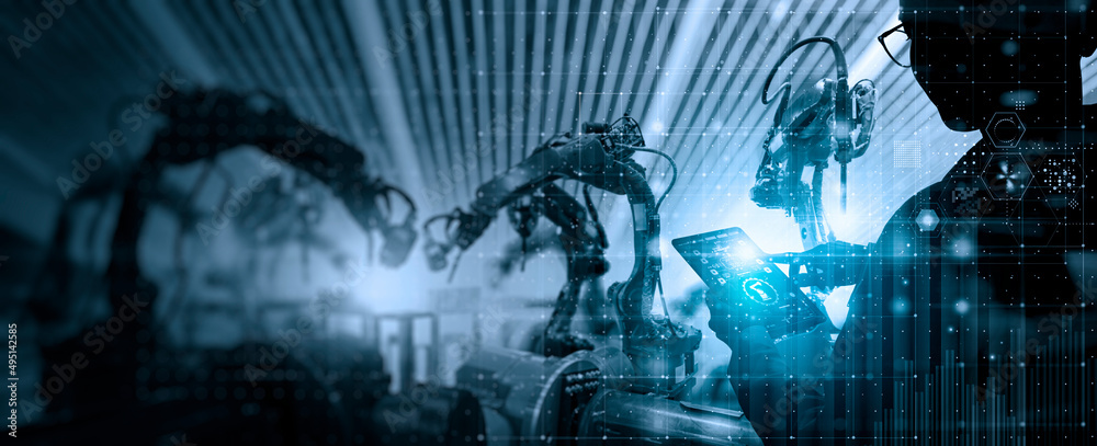 Factory Female Industrial Engineer working with automation robot arms machine in intelligent factory industrial on real time monitoring system software.Digital future manufacture.