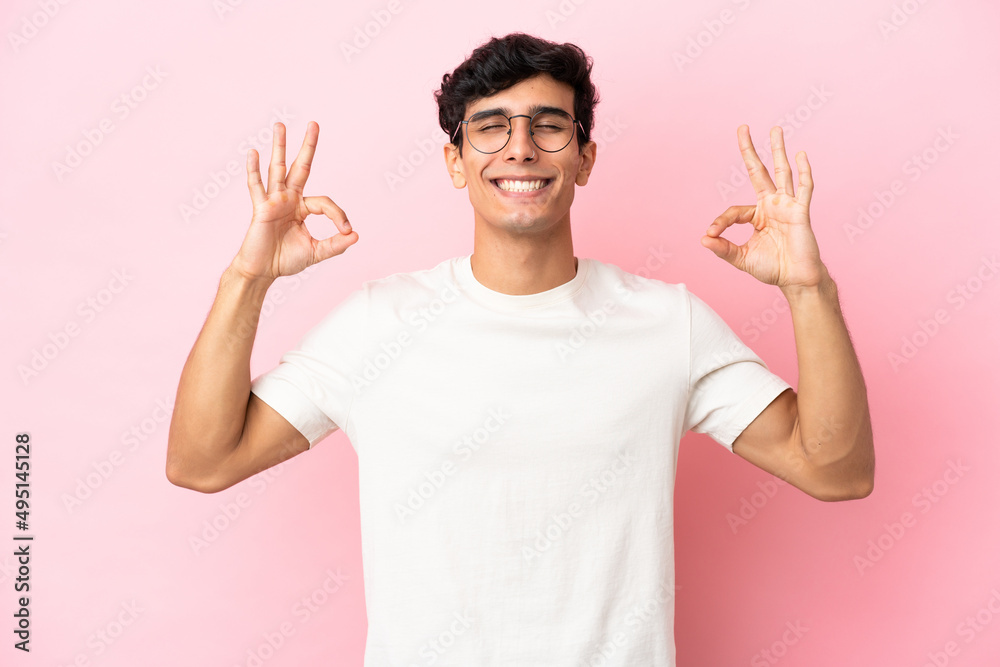 Young Argentinian man isolated on pink background in zen pose Young Argentinian man isolated on pink background in zen pose