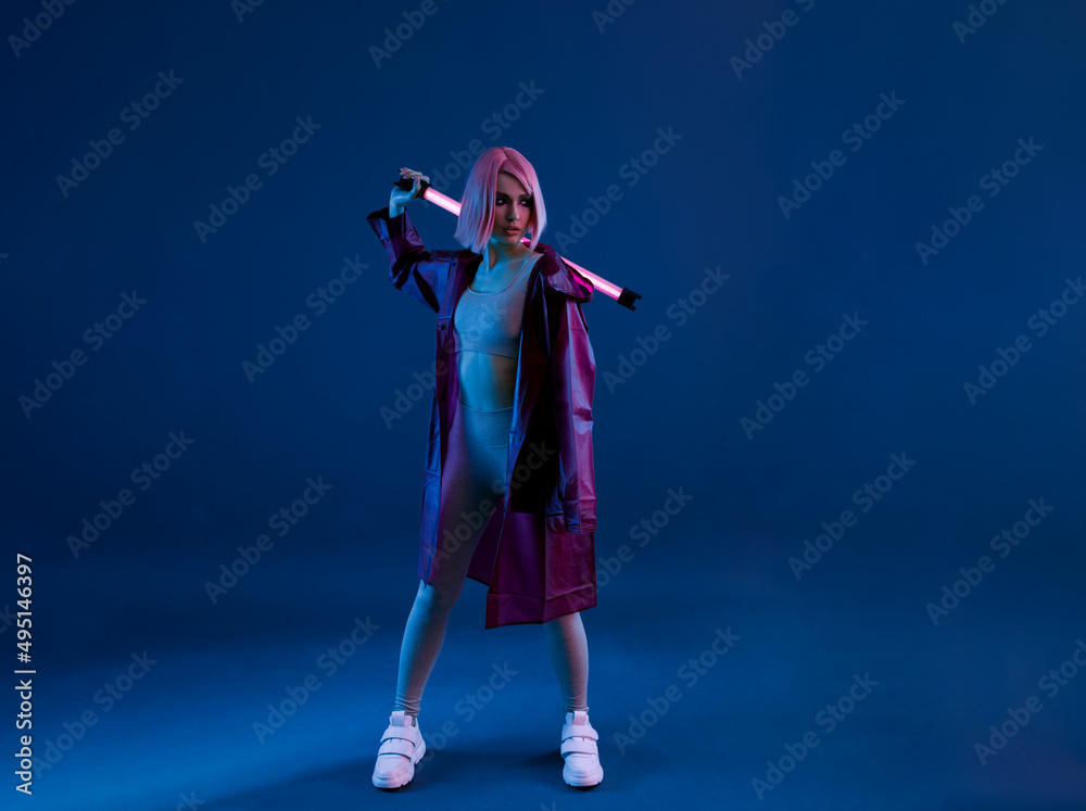 Fototapeta premium Woman in futuristic costume. Female in modern VR glasses interacting with network while having virtual reality experience. Augmented reality game, future technology, AI concept. VR. Neon violet light.