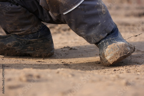 Dirty shoes on the feet of a child on a background of wet sand