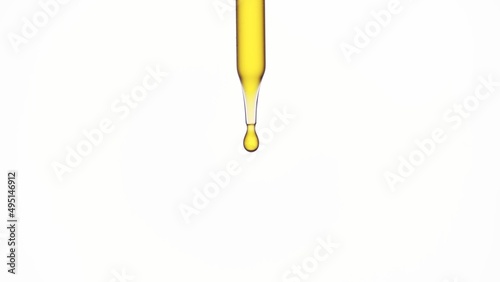 Macro shot of lab dropper with yellow oil on white background | Abstract skin care formulation concept photo
