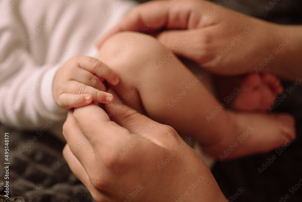 Legs and arms of a newborn and mother's hands Legs and arms of a newborn and mother's hands